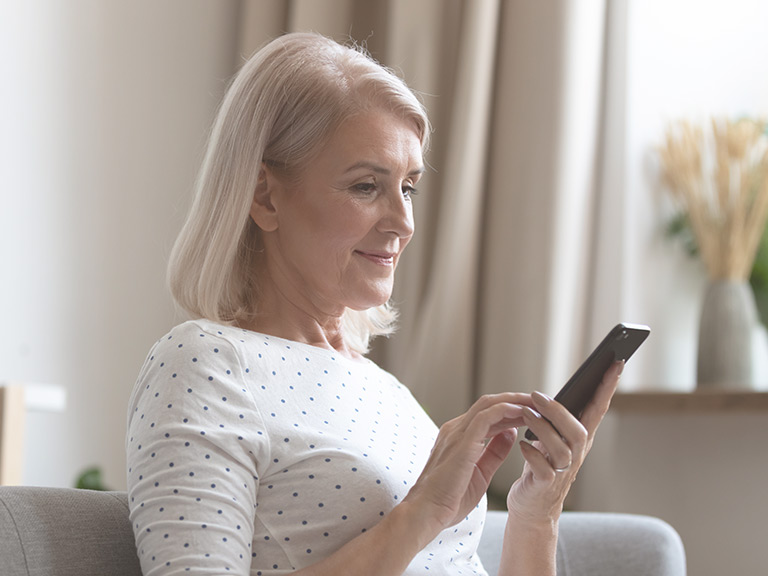 Sign Up For More News & Resources 1 Middle-aged woman reads email